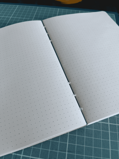 Le carnet style bullet journal ouvert avec des coutures apparentes